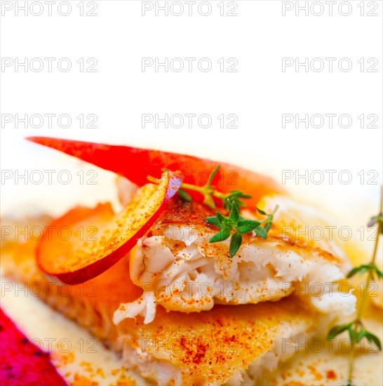 Sea bream orata fillet butter pan fried with fresh peach prune and dragonfruit slices thyme on top