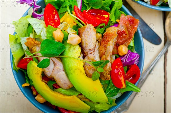 Fresh and healthy Chicken Avocado salad over rustic wood table