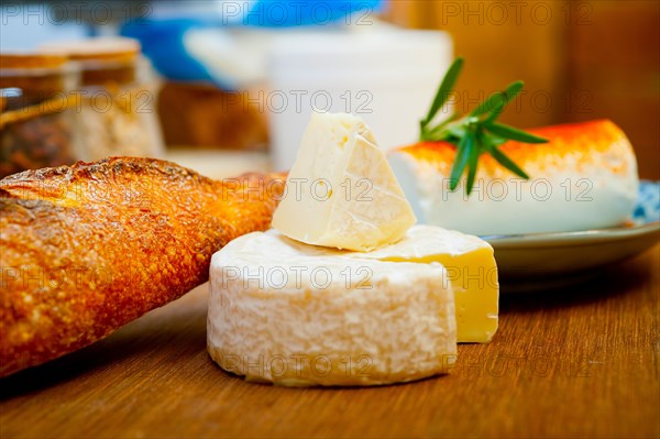 French cheese and fresh baguette on a wood cutter