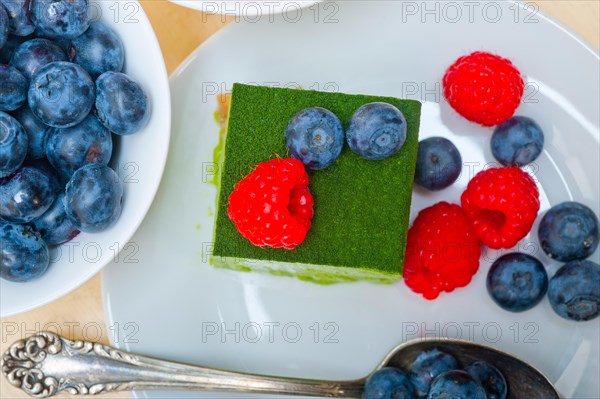 Green tea matcha mousse cake with raspberries and blueberries on top