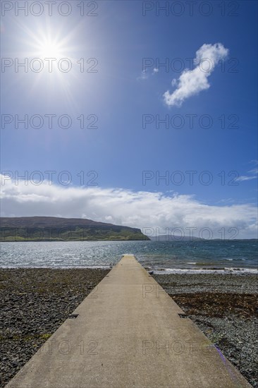 Concrete pier on sea with sun