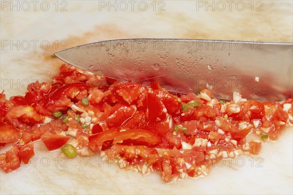 Chopping tomatoes and garlic for making chutney