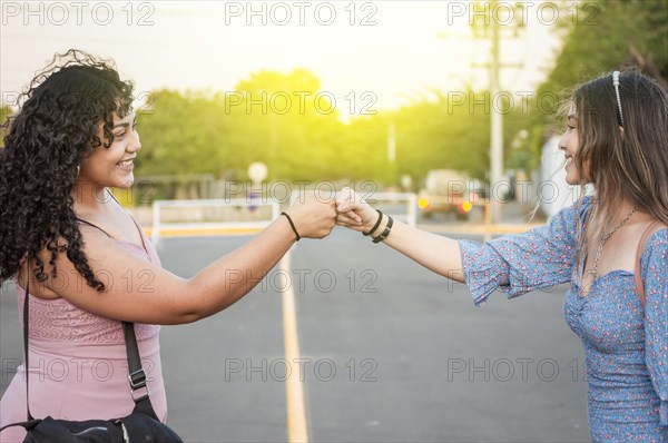 Two women greet each other friendly with fists