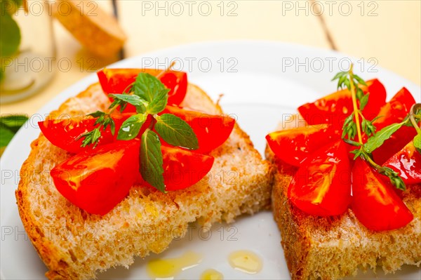 Italian tomato bruschetta with thyme and mint leaves