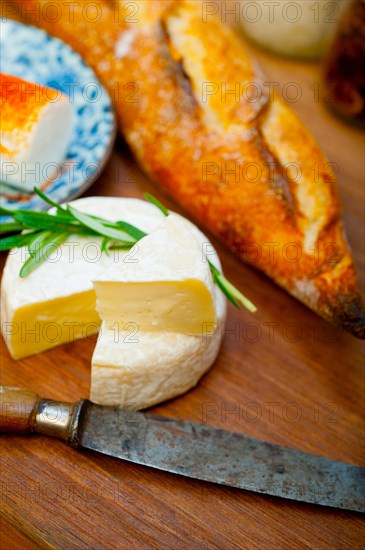 French cheese and fresh baguette on a wood cutter