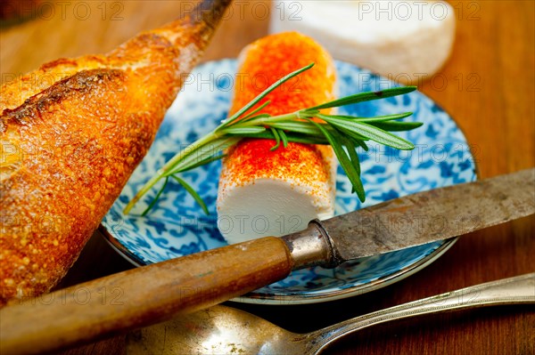 French cheese and fresh baguette on a wood cutter