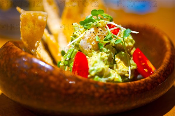 Fresh avocado and shrimps salad with nachos on side