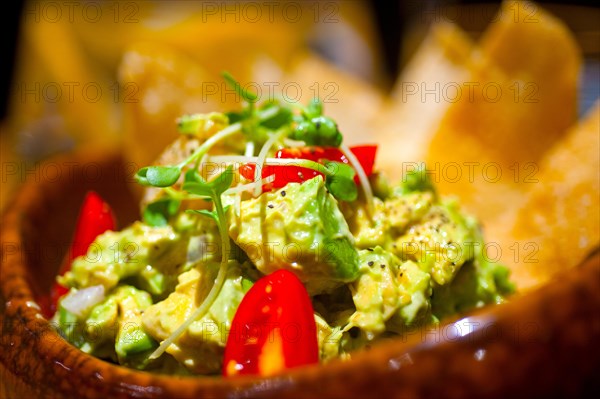 Fresh avocado and shrimps salad with nachos on side