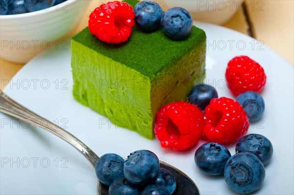 Green tea matcha mousse cake with raspberries and blueberries on top