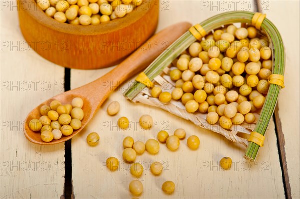 Organic soya beans over rustic wood table macro closeup