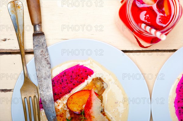 Sea bream orata fillet butter pan fried with fresh peach prune and dragonfruit slices thyme on top