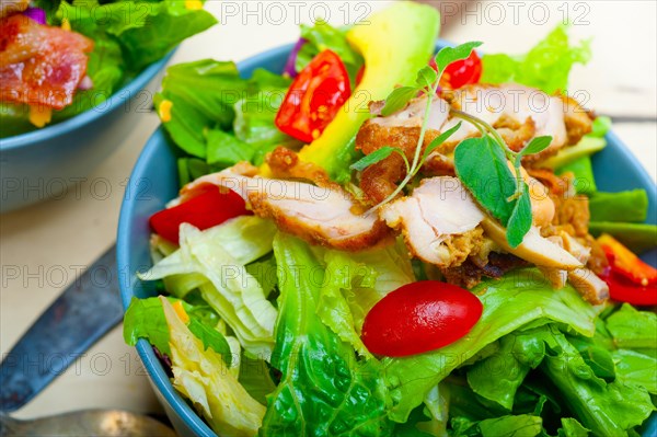 Fresh and healthy Chicken Avocado salad over rustic wood table