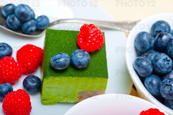 Green tea matcha mousse cake with raspberries and blueberries on top