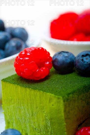 Green tea matcha mousse cake with raspberries and blueberries on top