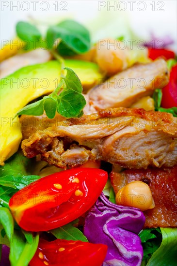 Fresh and healthy Chicken Avocado salad over rustic wood table