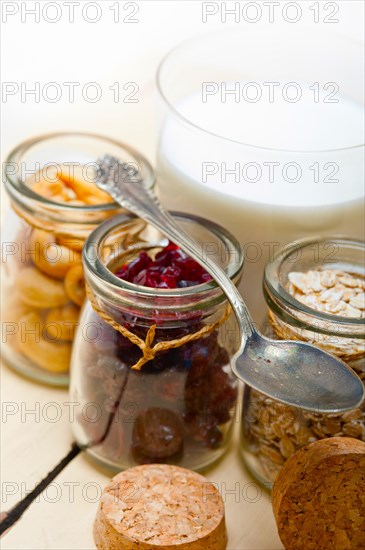 Healthy breakfast ingredients milk oat cashew nuts dried cramberry craisinns