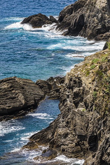 Steep cliffs washed by water on the Ligurian coast off Vernazza