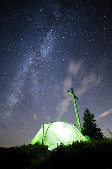 Green tent with summit cross under a starry sky on Portlakopf