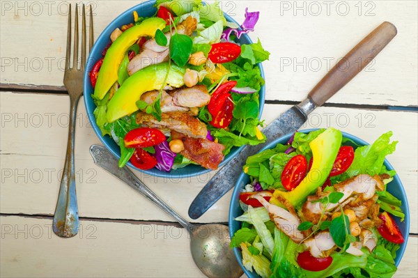 Fresh and healthy Chicken Avocado salad over rustic wood table