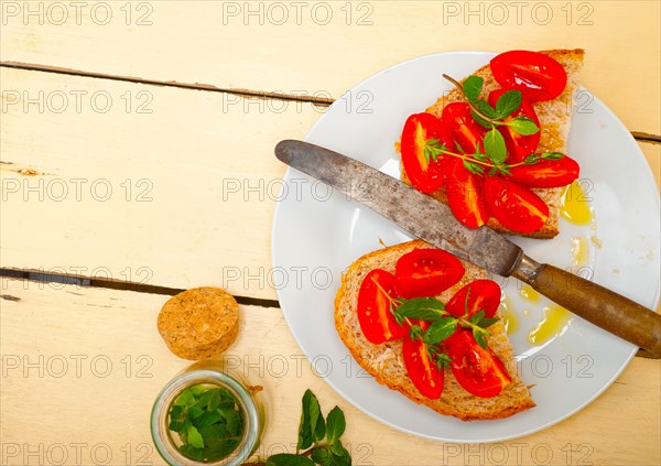 Italian tomato bruschetta with thyme and mint leaves