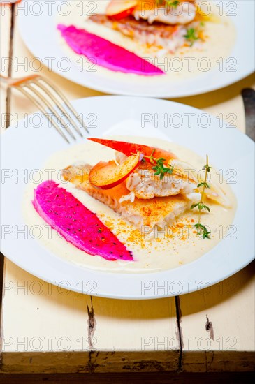 Sea bream orata fillet butter pan fried with fresh peach prune and dragonfruit slices thyme on top