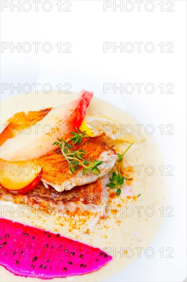 Sea bream orata fillet butter pan fried with fresh peach prune and dragonfruit slices thyme on top