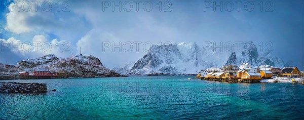 Panorama of yellow rorbu houses of Sakrisoy fishing village with snow in winter. Lofoten islands