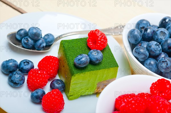 Green tea matcha mousse cake with raspberries and blueberries on top