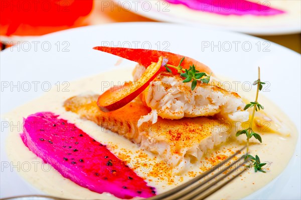 Sea bream orata fillet butter pan fried with fresh peach prune and dragonfruit slices thyme on top