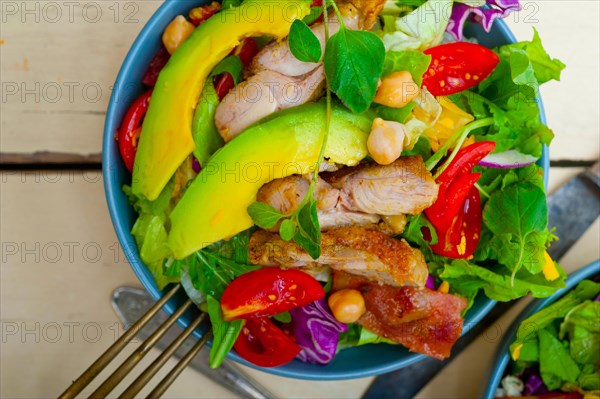 Fresh and healthy Chicken Avocado salad over rustic wood table