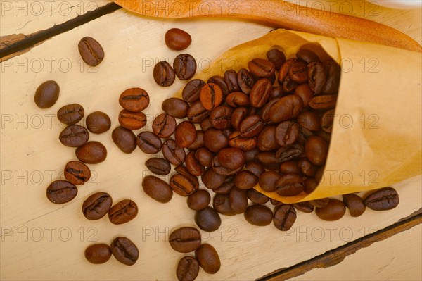 Espresso coffee and beans on a paper cone cornucopia over white background