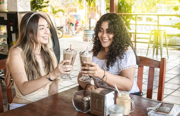 Two girls drink a milkshake