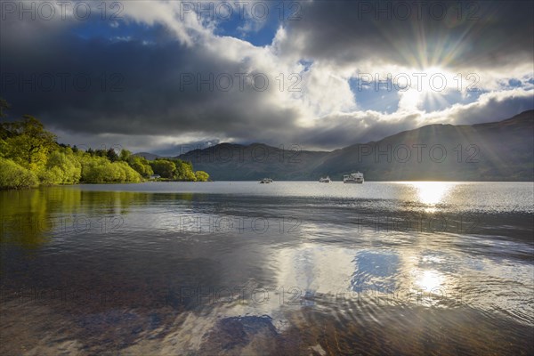 Lake with dramatic clouds and sun in spring