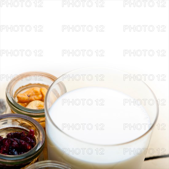 Healthy breakfast ingredients milk oat cashew nuts dried cramberry craisinns