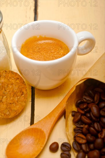 Espresso coffee and beans on a paper cone cornucopia over white background