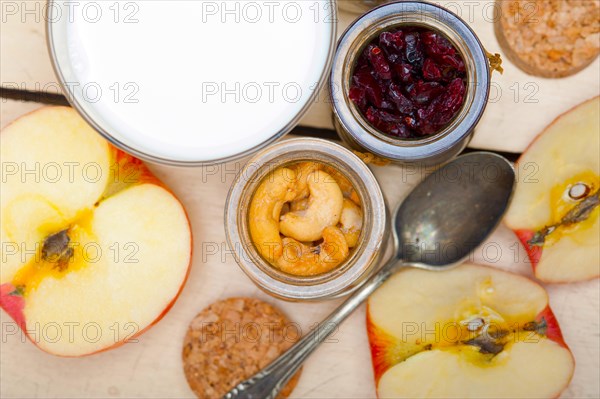 Healthy breakfast ingredients milk oat cashew nuts dried cramberry craisinns