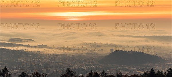 Panorama of Graz city covered in fog on autumn morning during sunrise