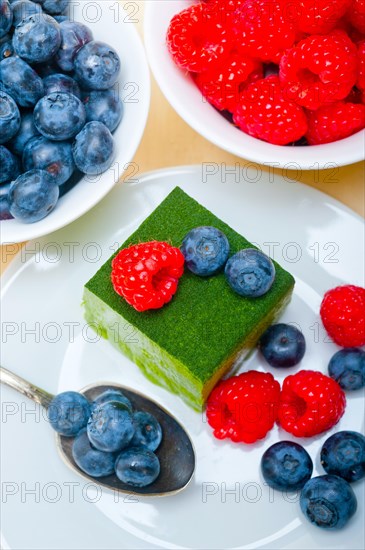 Green tea matcha mousse cake with raspberries and blueberries on top