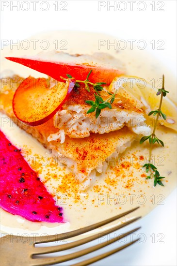 Sea bream orata fillet butter pan fried with fresh peach prune and dragonfruit slices thyme on top