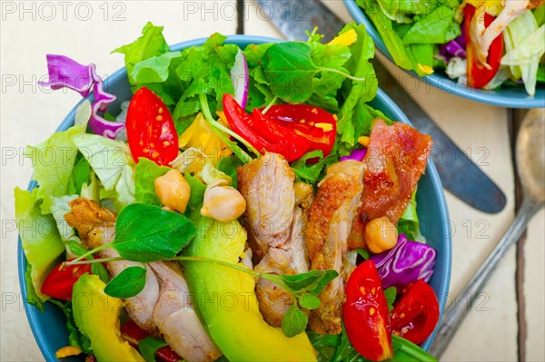 Fresh and healthy Chicken Avocado salad over rustic wood table