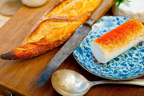 French cheese and fresh baguette on a wood cutter