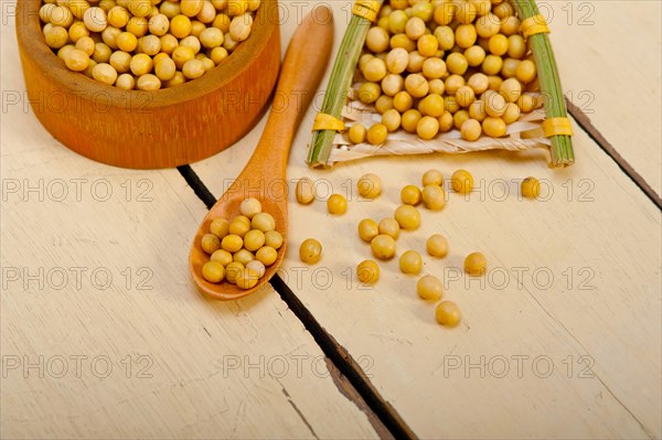 Organic soya beans over rustic wood table macro closeup