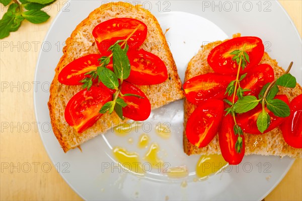 Italian tomato bruschetta with thyme and mint leaves