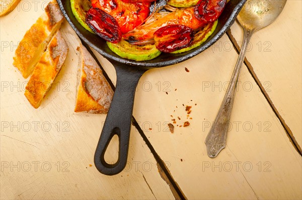 Roasted shrimps on cast iron skillet with zucchini and tomatoes