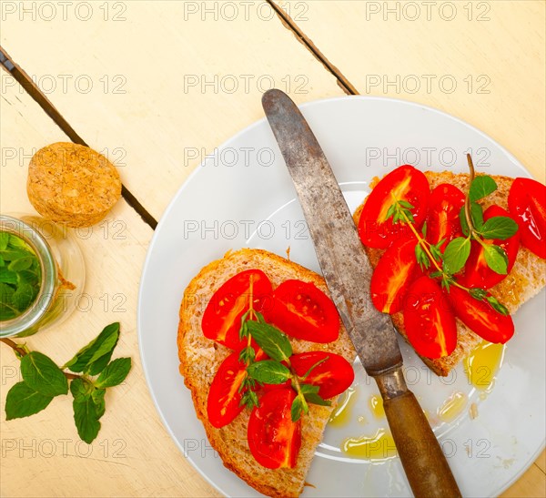 Italian tomato bruschetta with thyme and mint leaves