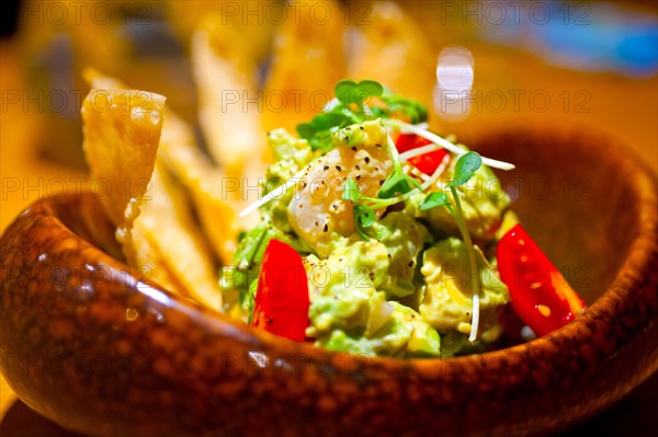 Fresh avocado and shrimps salad with nachos on side