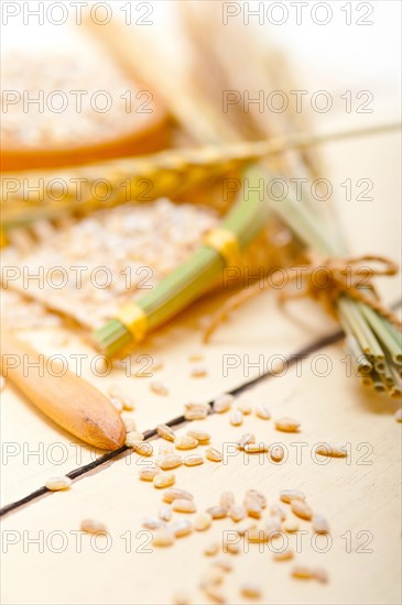 Organic wheat grains over rustic wood table macro closeup