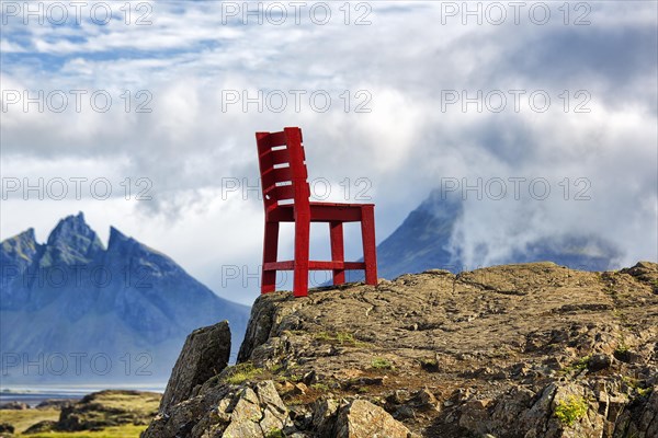 Red wooden chair on a rock