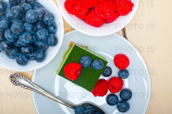 Green tea matcha mousse cake with raspberries and blueberries on top