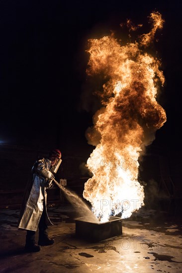 Firefighter extinguishes a heptane 2B-Pan fire with a 2-BTP extinguisher